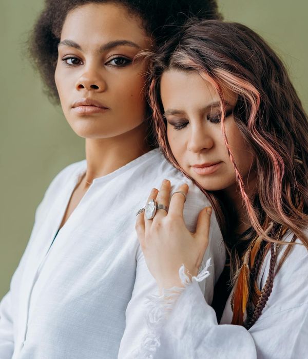A woman in a calm yoga pose, surrounded by a soft pink aura.